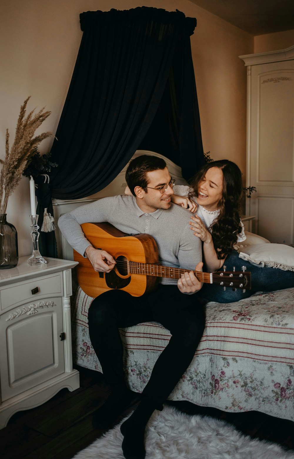 man and woman sitting on bed