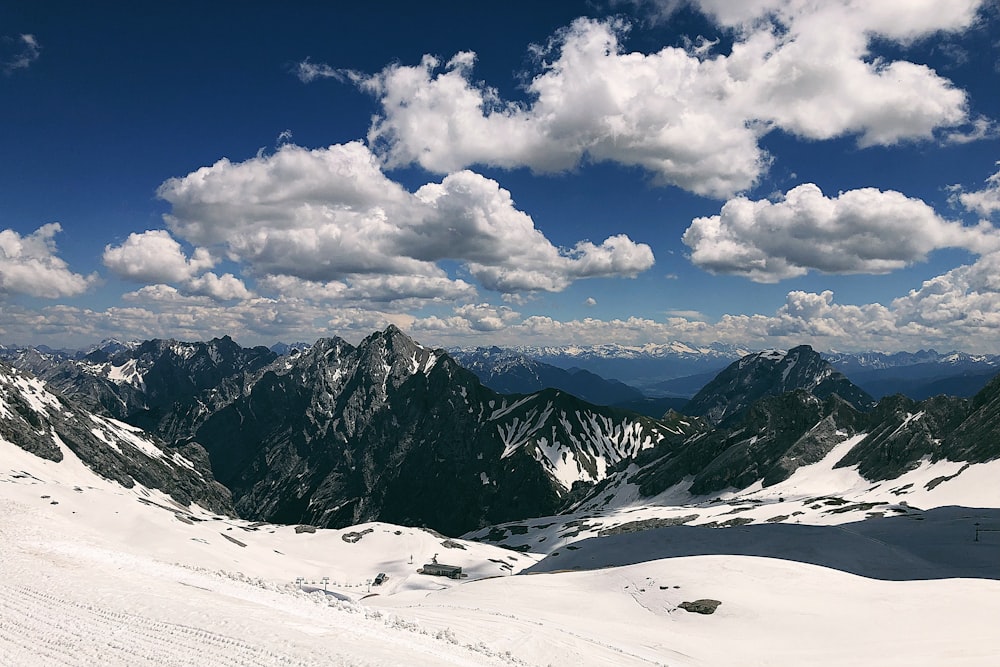 snow covered mountain under white clouds and blue sky during daytime