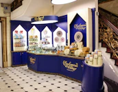 Elegant packaging of sweets with teal blue and green accents reflecting the brand colors.