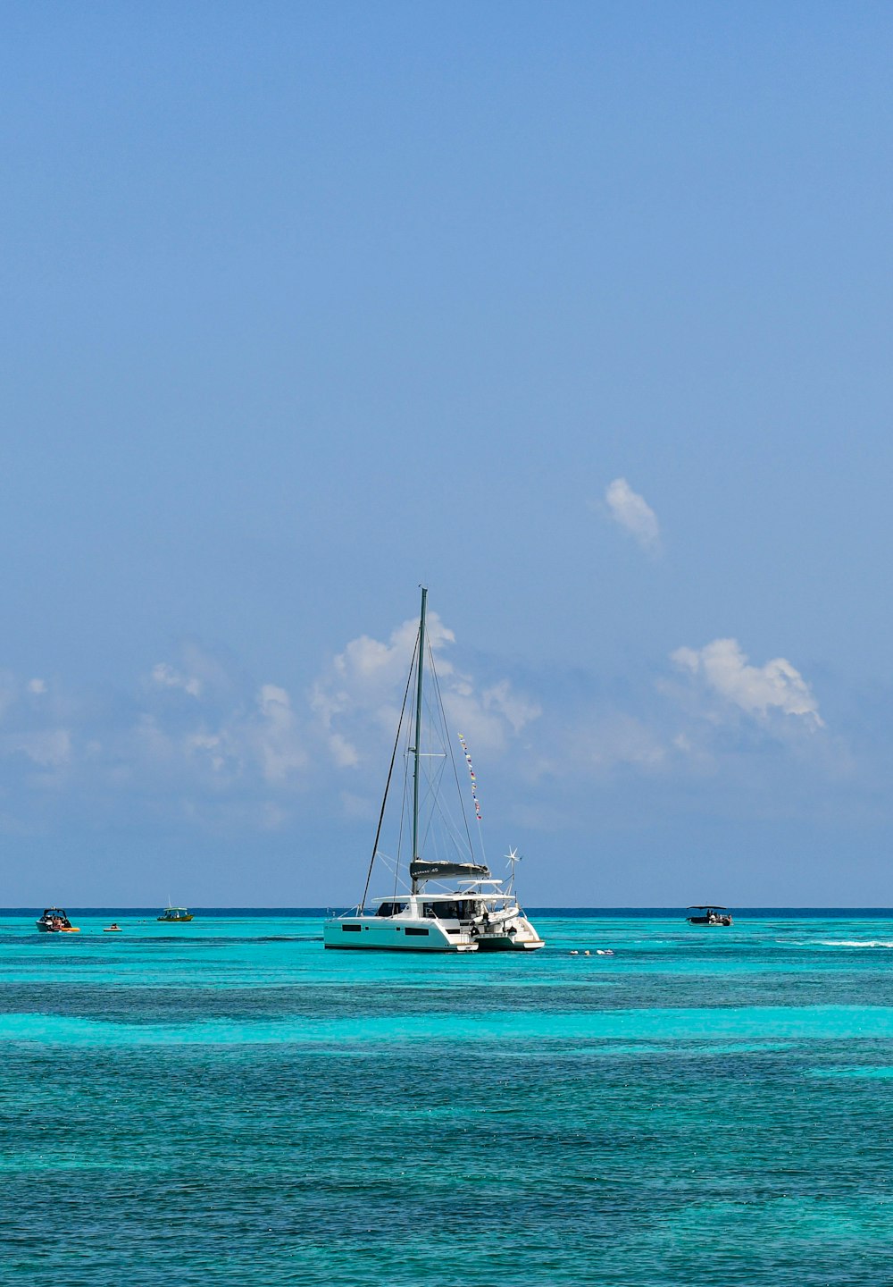 white sailboat on sea under blue sky during daytime