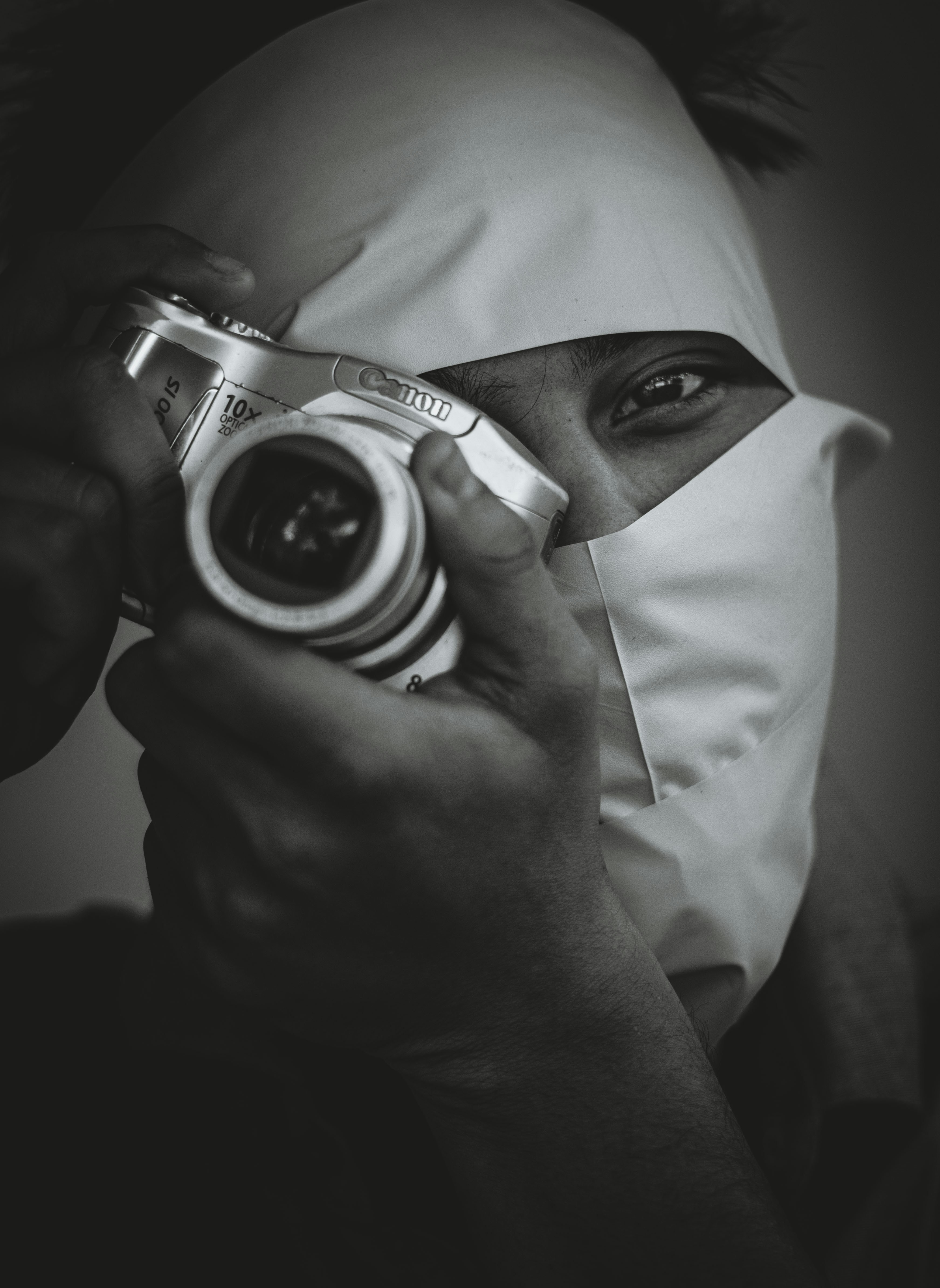 person wearing white hijab holding camera