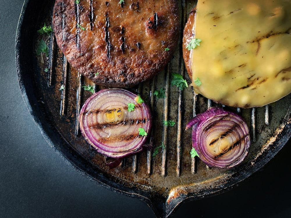 fried meat with sliced cucumber on black plate