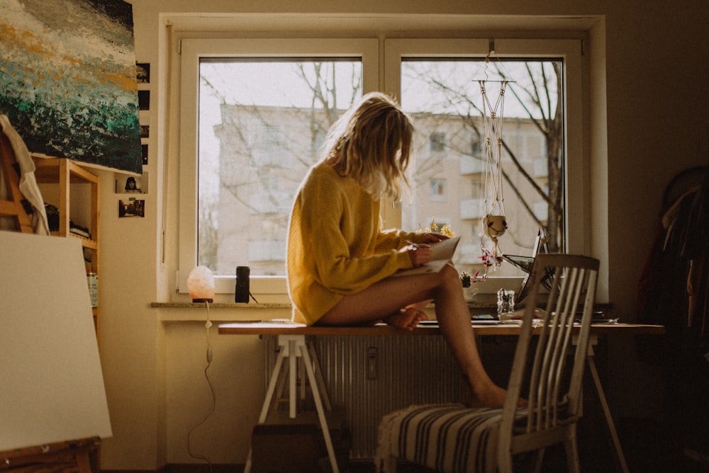 woman in yellow sweater sitting on chair