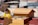 person in yellow jacket holding brown wooden box
