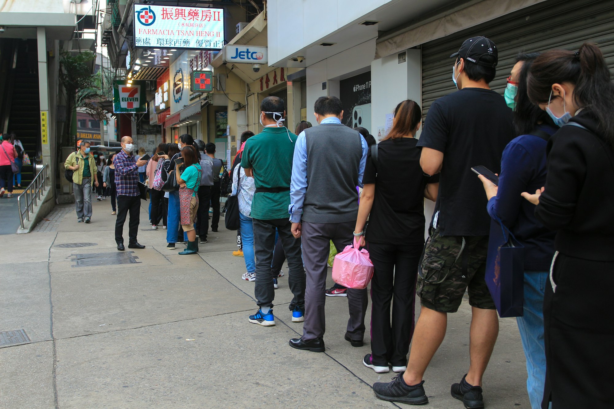 People in Macau, queue up to acquire face masks in a pharmacy under a program established by the government to supply all the population with masks to avoid hoarding and stock ruptures and price hikes. (RW)