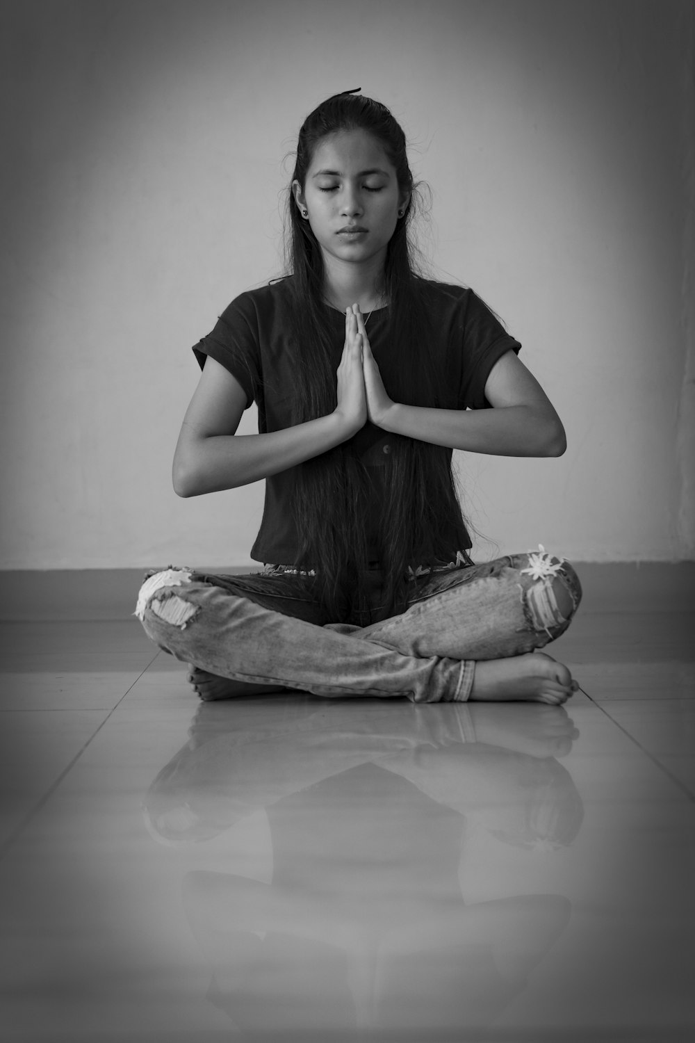 woman in black t-shirt and gray denim jeans sitting on floor