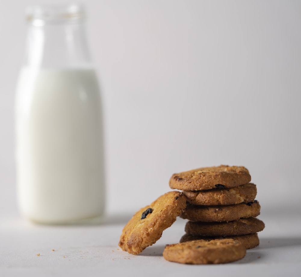 cookies beside milk in glass bottle