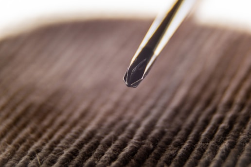 Close-up of a hand gripping a sturdy screwdriver against a wooden background