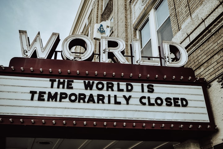 movie sign with the words, 'the world is temporarily closed' written on it covid-19 lockdown