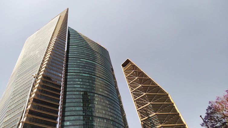 Sleek and modern luxury construction site with glass facades and contemporary architecture under a clear sky.