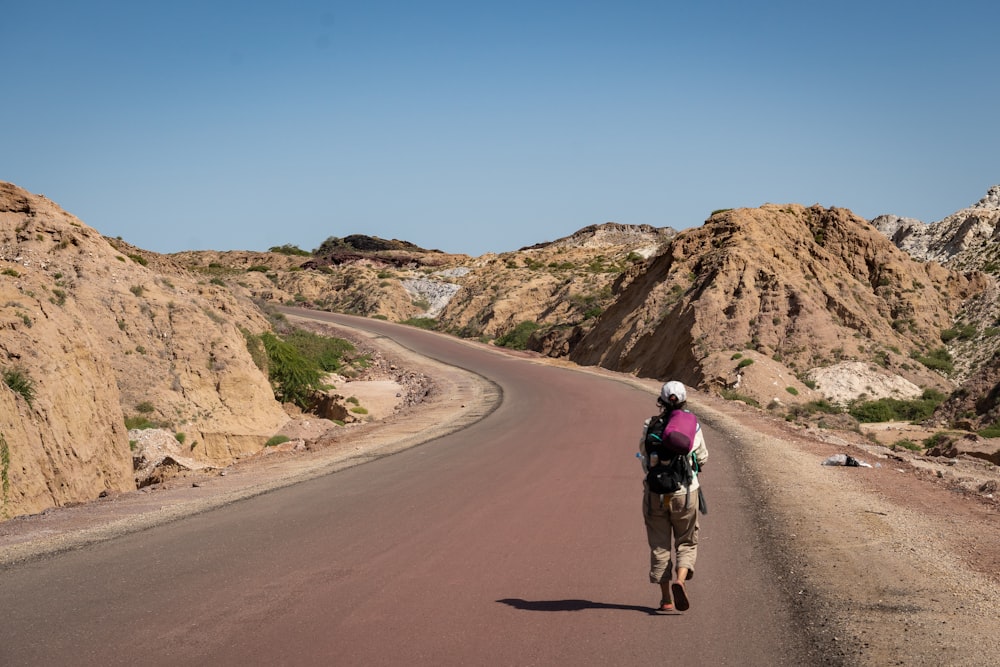 man in black jacket riding on brown horse on brown dirt road during daytime