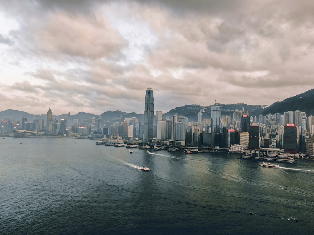 city skyline across body of water under cloudy sky during daytime