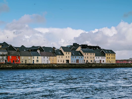White and brown concrete building beside body of water during daytime — Galway, Ireland