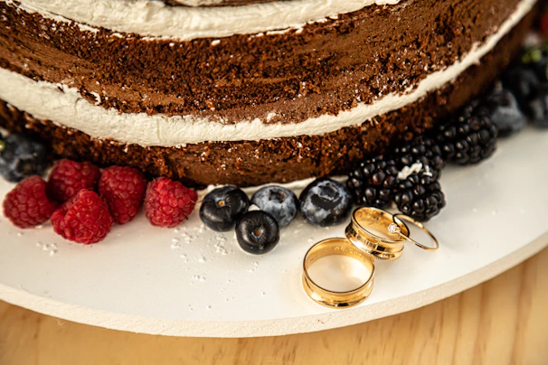 Close-up of a chocolate layered cake with glossy ganache and fresh berries on top.