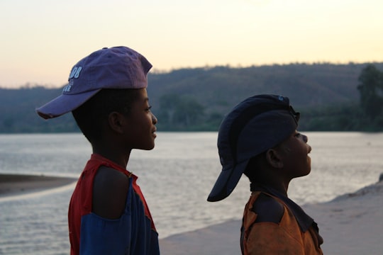 2 men wearing blue and red backpacks on beach during daytime in Belo Tsiribihina Madagascar