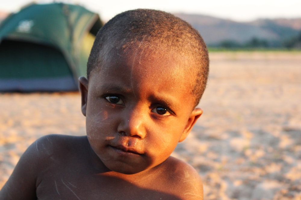 topless boy on beach during daytime