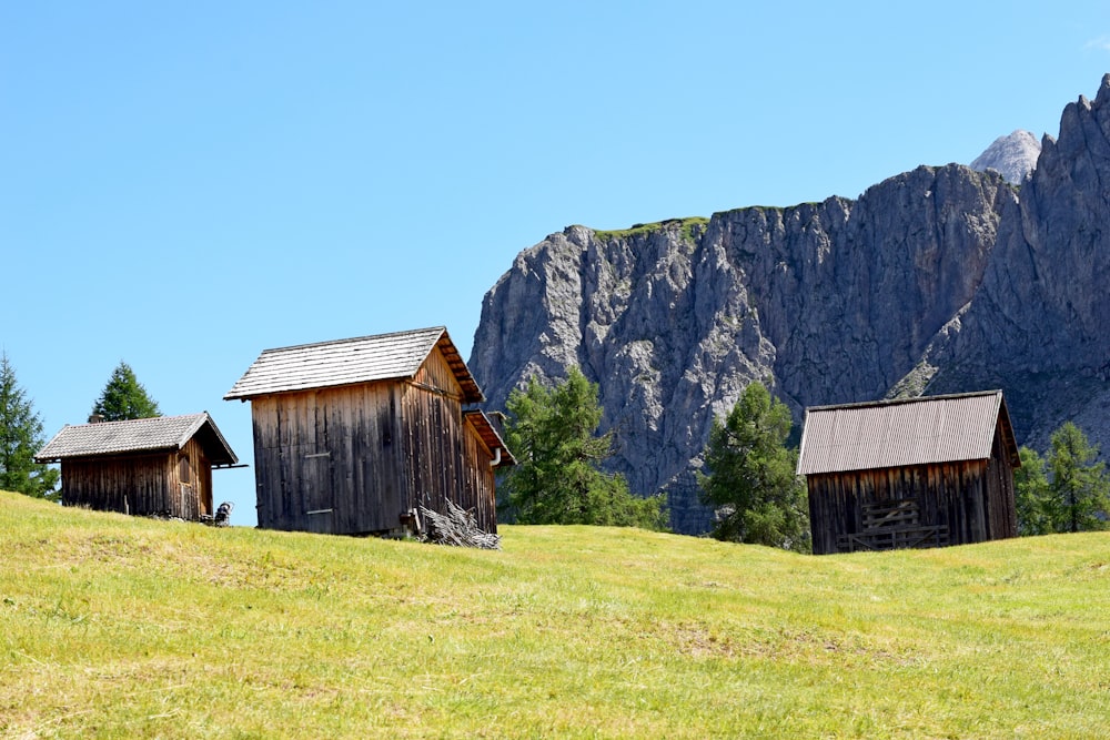 Braunes Holzhaus auf grünem Grasfeld in der Nähe von Gray Rocky Mountain tagsüber