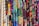A vibrant assortment of fabrics is displayed, each featuring unique and intricate patterns. The patterns include various shapes, designs, and colors, ranging from geometric to floral motifs, set against both dark and bright backgrounds.