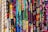 A vibrant assortment of fabrics is displayed, each featuring unique and intricate patterns. The patterns include various shapes, designs, and colors, ranging from geometric to floral motifs, set against both dark and bright backgrounds.