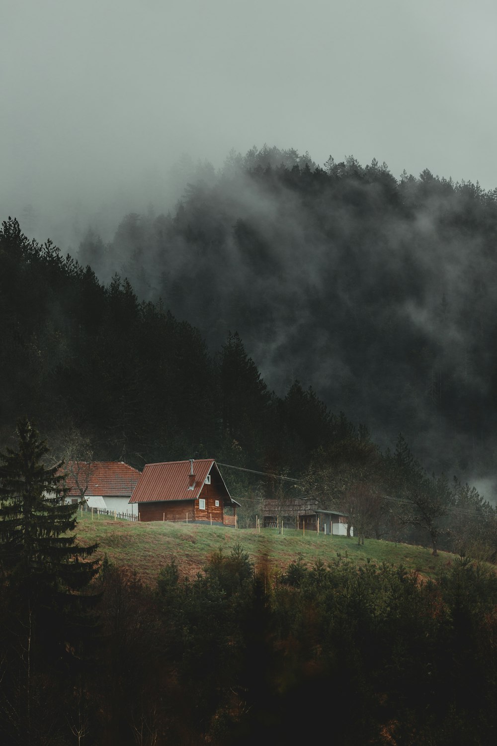 brown and white house near green trees under white clouds