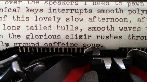 A close-up view of an old typewriter with a page containing typewritten text. The text is composed of random sentences with a nostalgic and poetic feel. The typewriter's mechanical components, including the ribbon and typebar, are visible.
