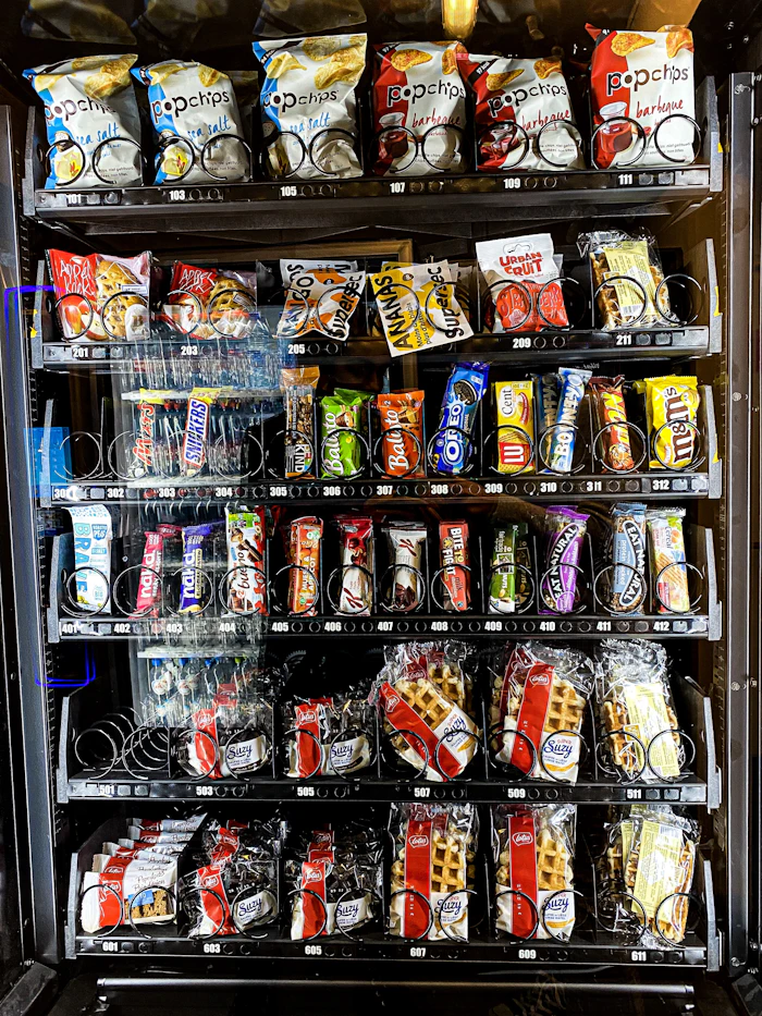 Snack vending machine shelf stocked with chips and candy