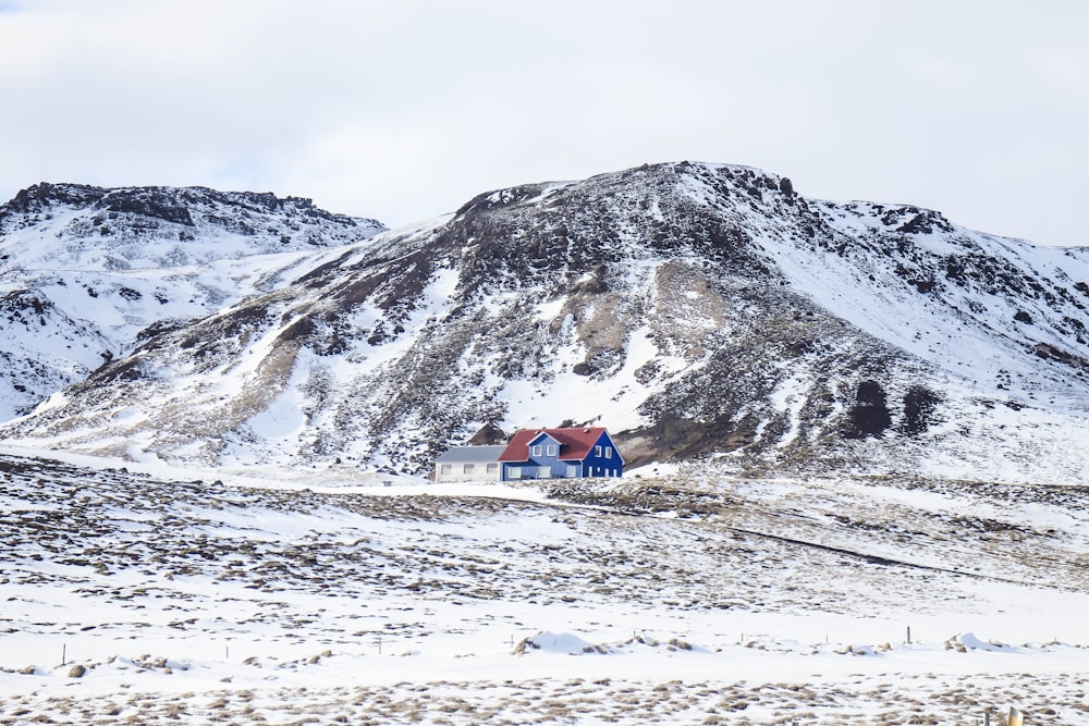 brown and white house on snow covered ground near snow covered mountain during daytime