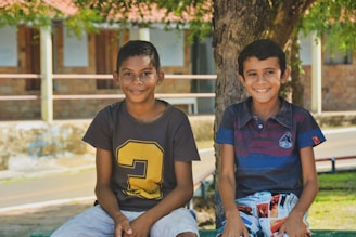 boy in blue crew neck t-shirt sitting beside boy in blue crew neck t-shirt