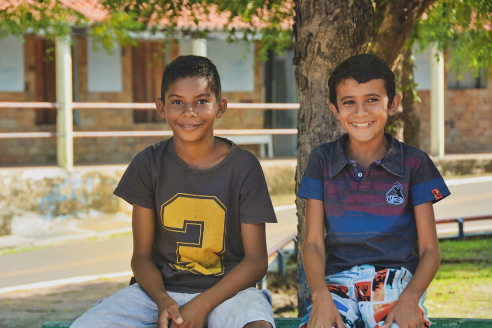 boy in blue crew neck t-shirt sitting beside boy in blue crew neck t-shirt