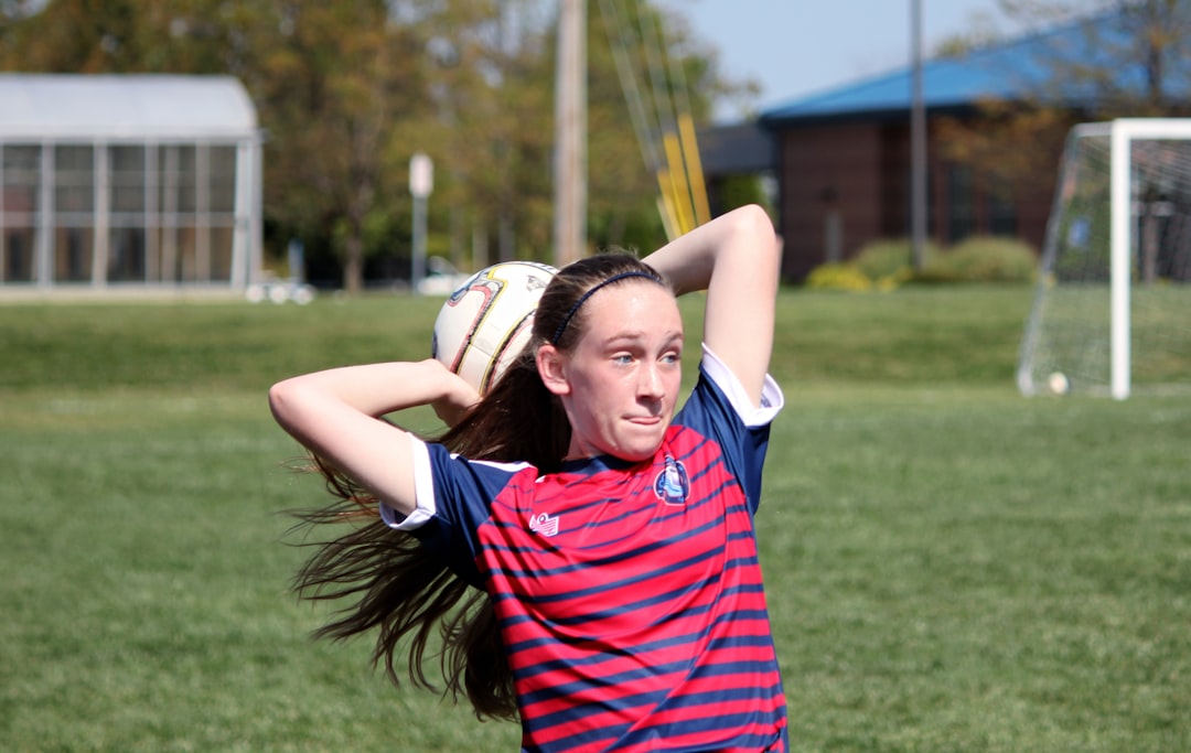 A girl throws a soccer ball.