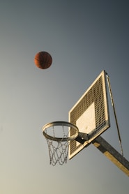 basketball on basketball hoop under blue sky during daytime