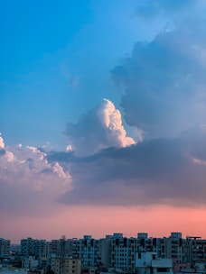 Cloud computing icons overlaying a city skyline at dusk, symbolizing cloud solutions.