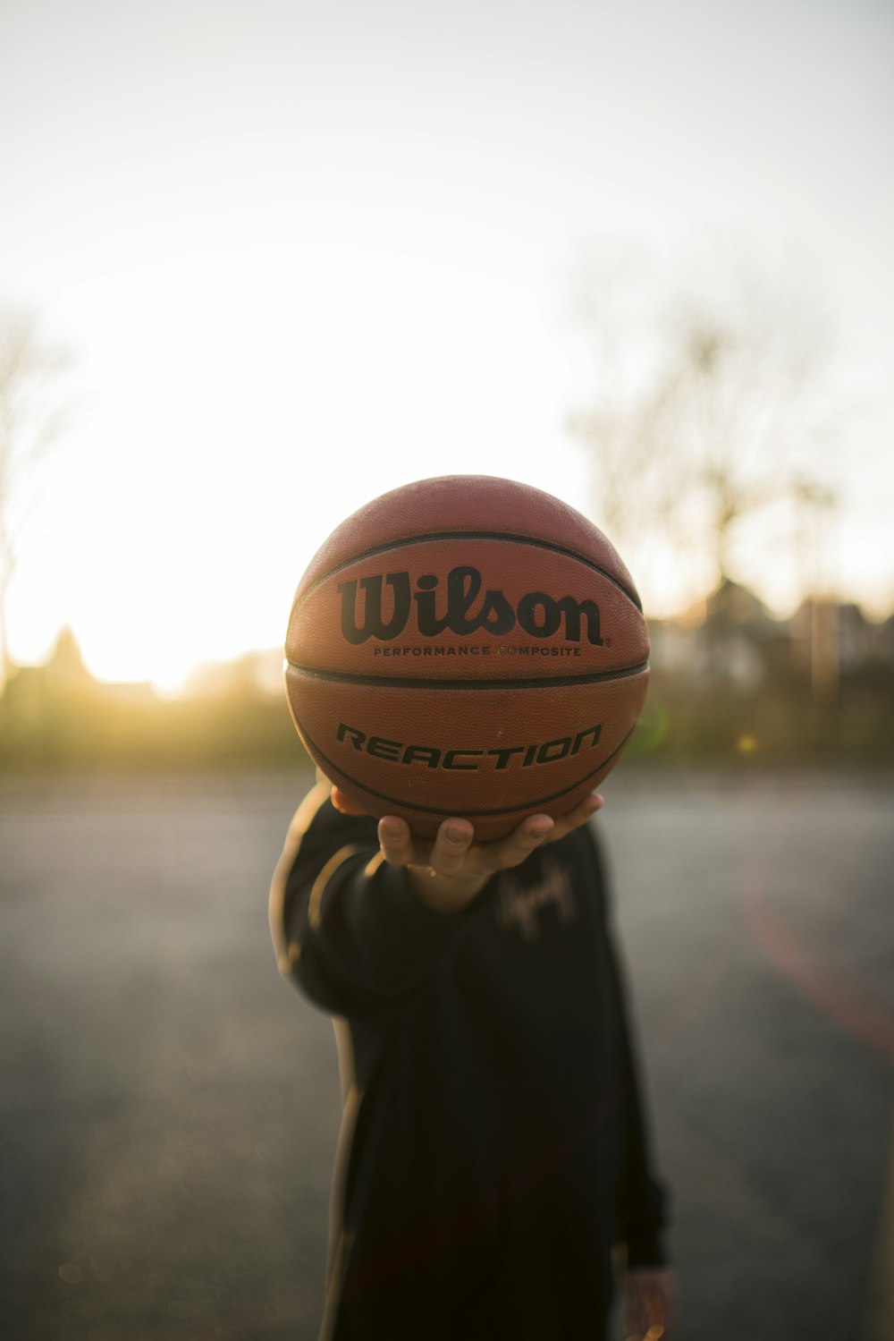 person holding brown basketball during daytime