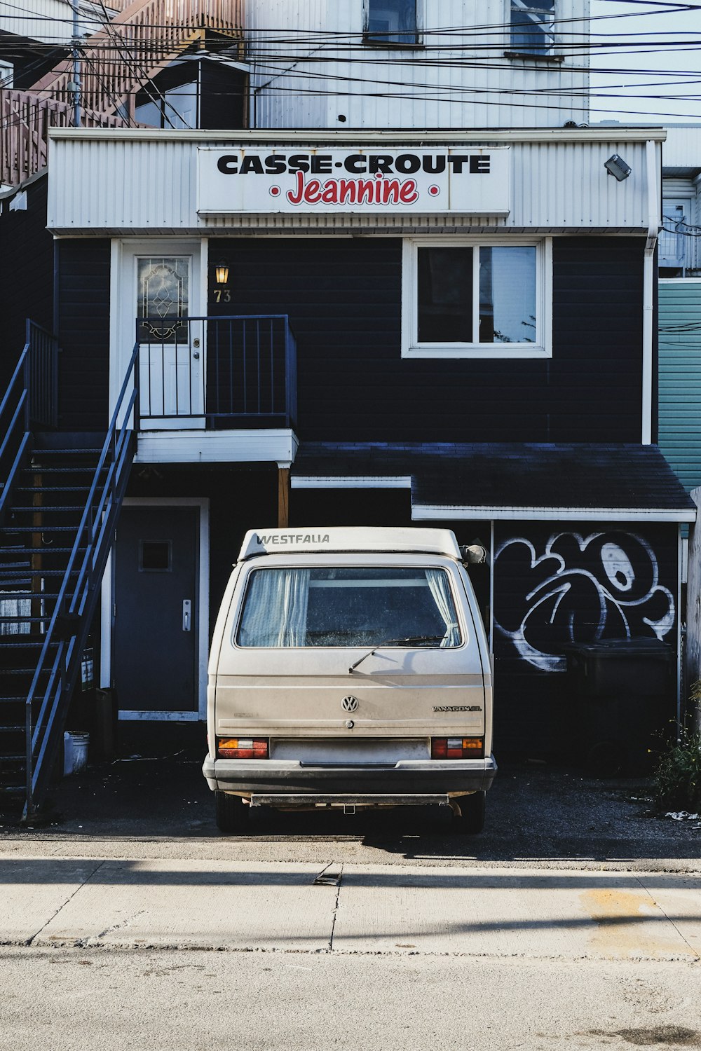 white van parked beside white and black building