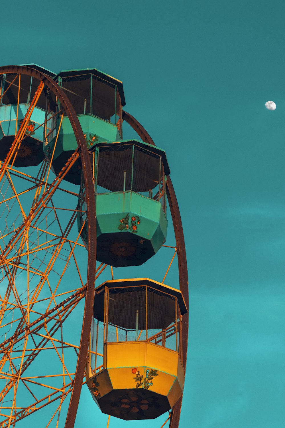 a ferris wheel with a half moon in the background