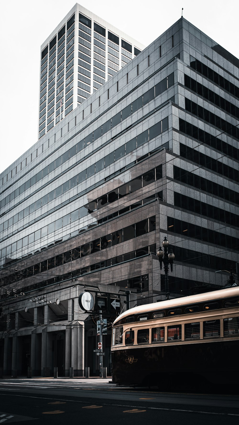 orange bus on road near white concrete building during daytime