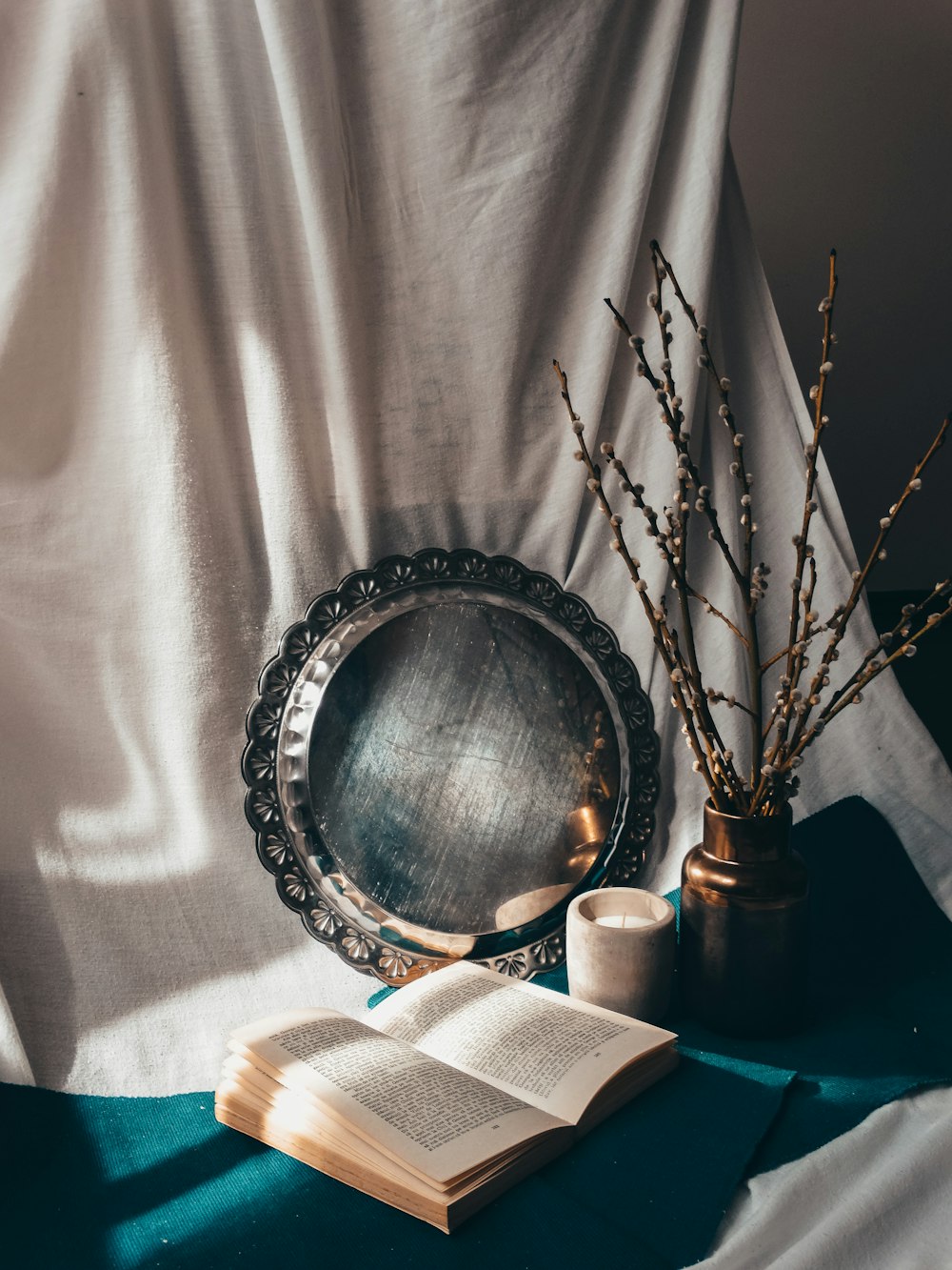 silver round framed mirror on white textile