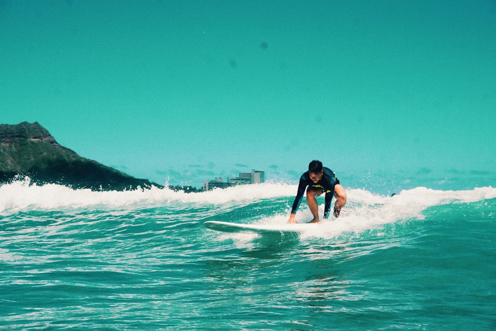 man surfing on sea waves during daytime