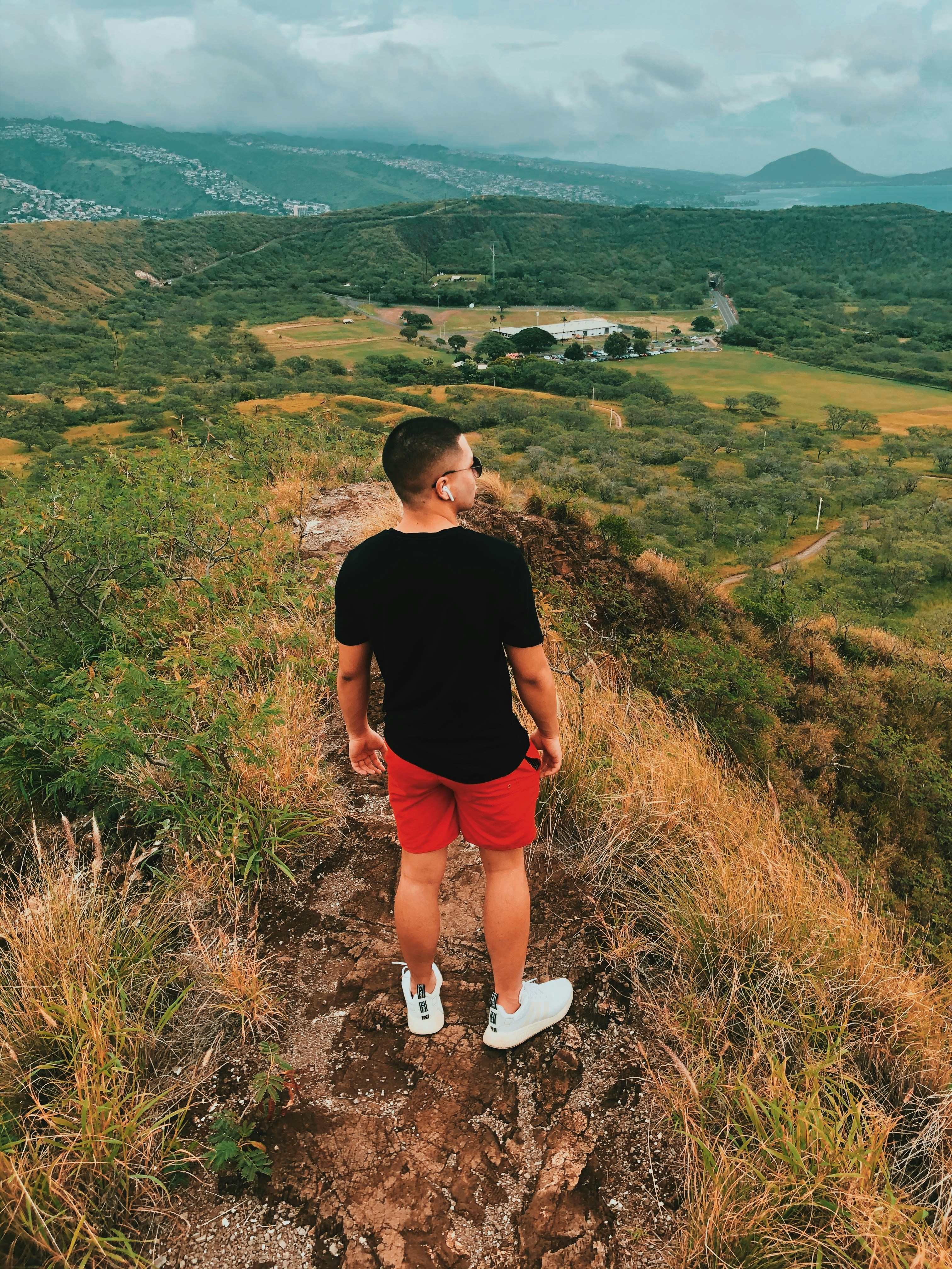 man in black crew neck t-shirt standing on green grass field during daytime
