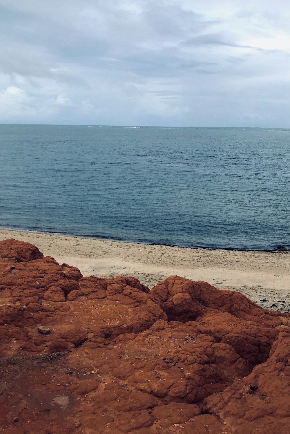 brown rock formation near body of water during daytime