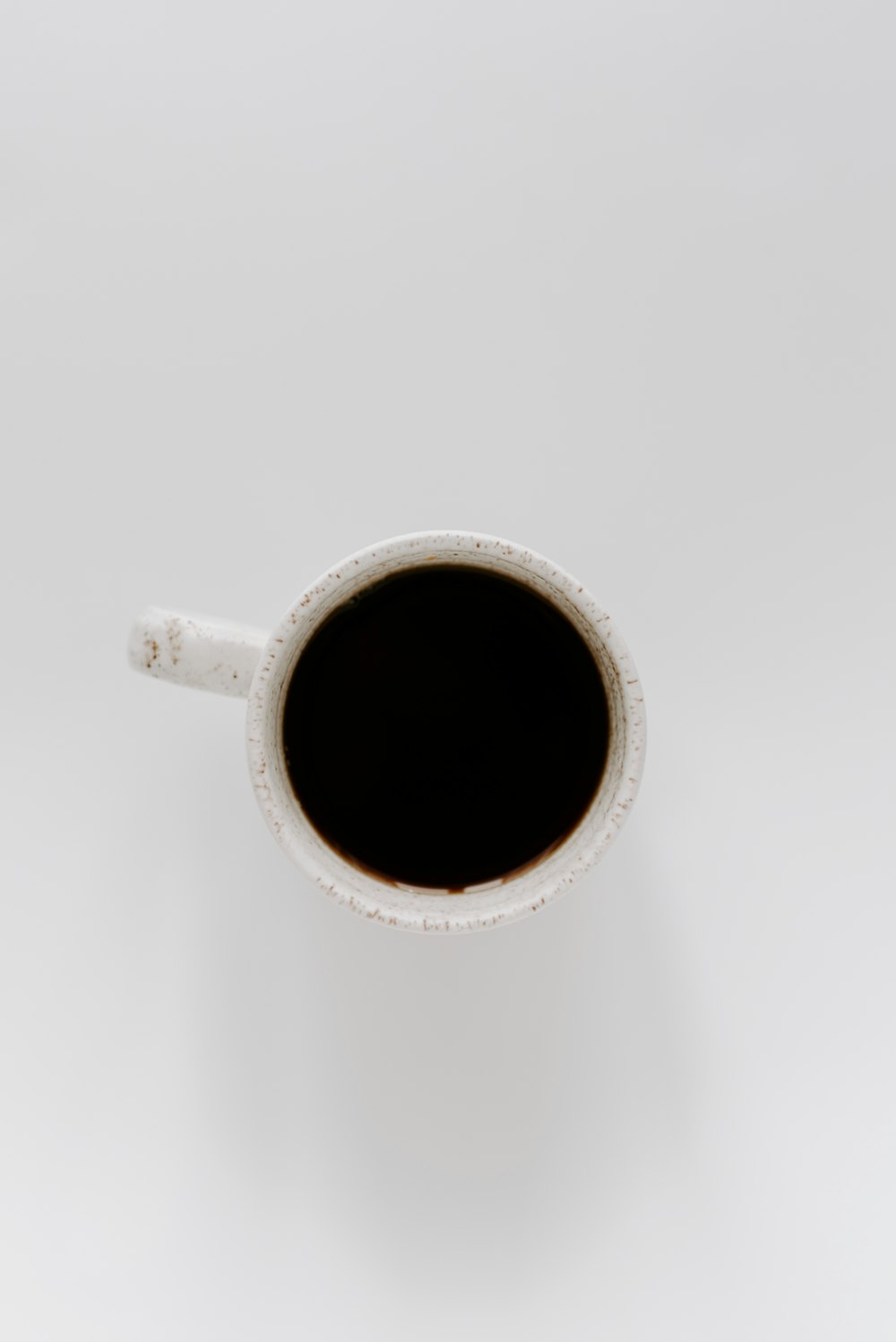 white ceramic mug with black liquid