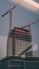Image showing a commercial building under construction with cranes in the background.