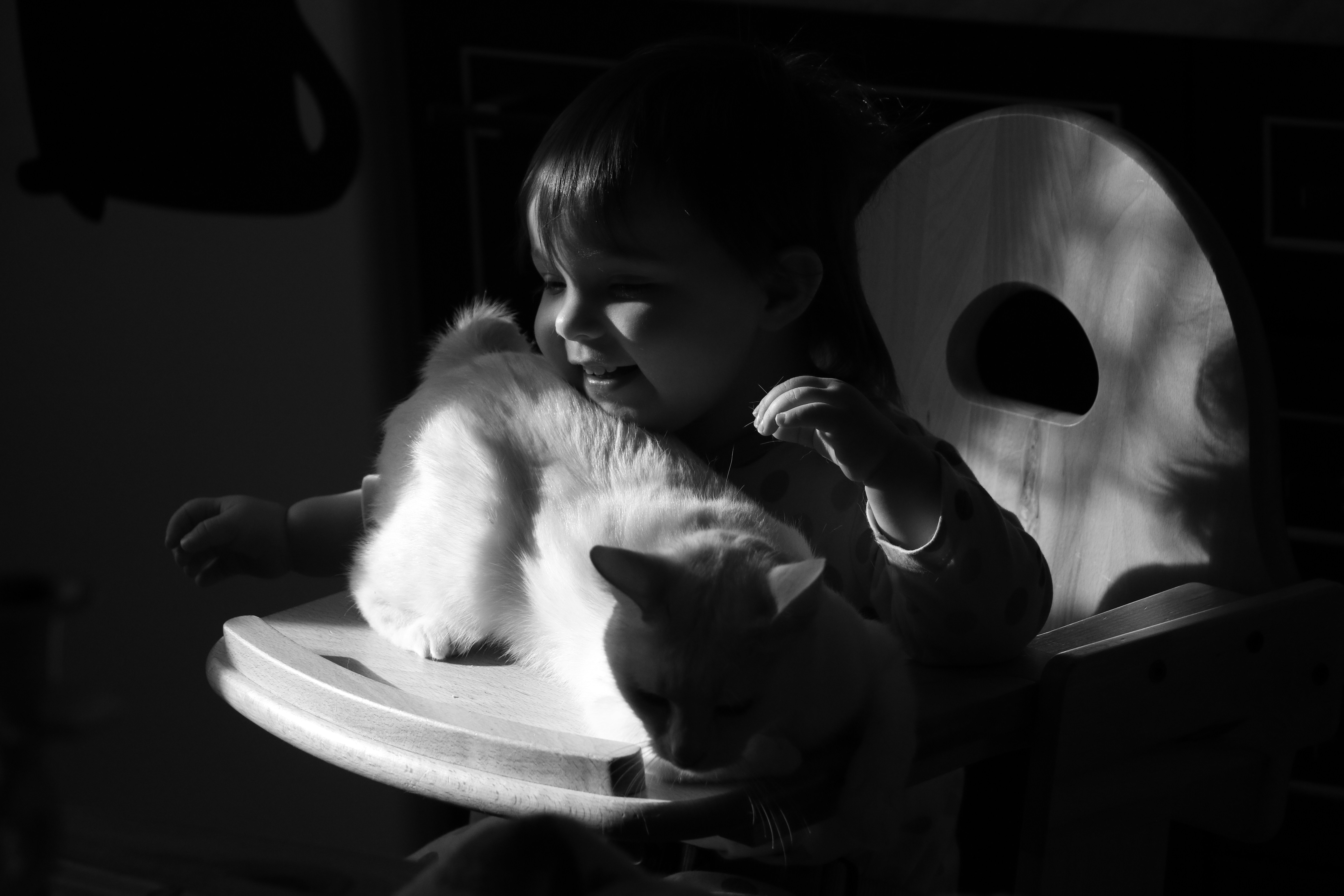 grayscale photo of girl kissing cat