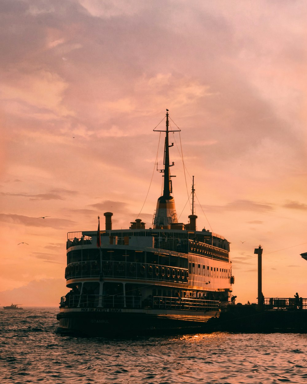 Weißes und schwarzes Schiff auf See bei Sonnenuntergang