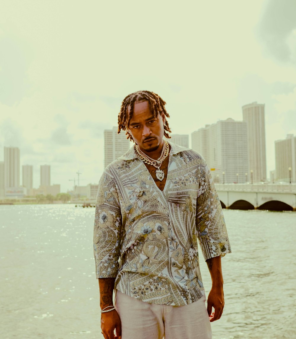 man in blue and white button up shirt standing on beach during daytime