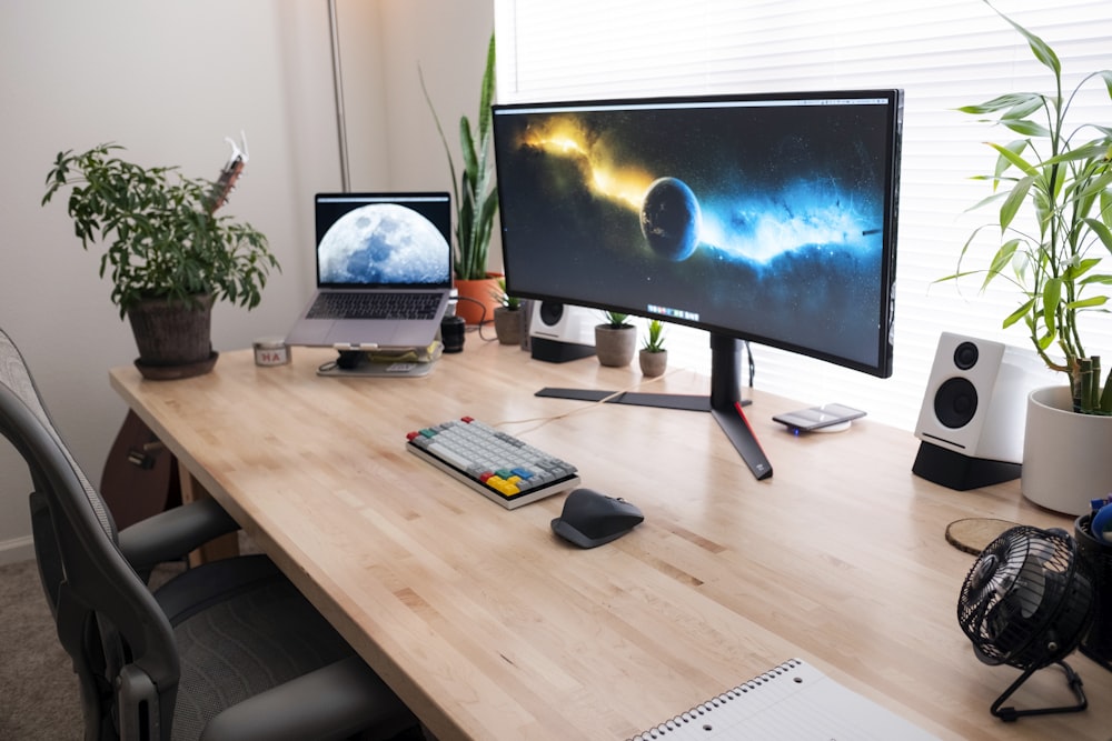 monitor de computador de tela plana preta na mesa de madeira marrom