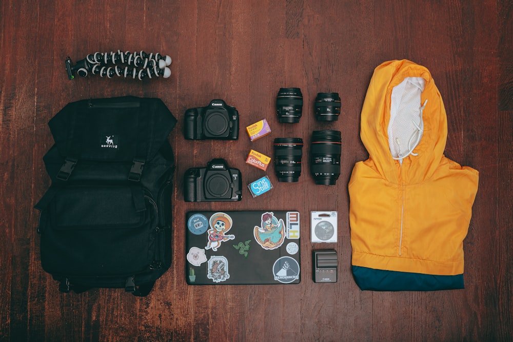 black dslr camera lens and yellow jacket on brown wooden table