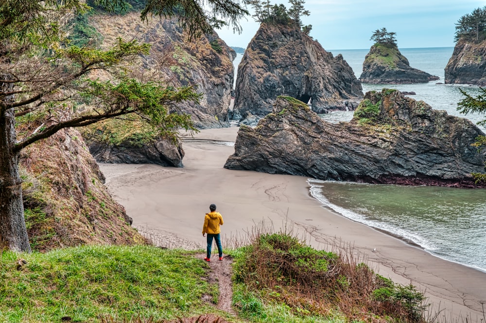 woman in yellow shirt walking on beach during daytime