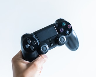 person holding black sony ps 4 game controller