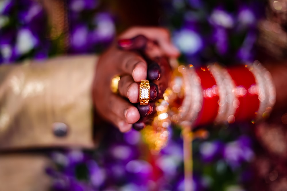 person holding beaded yellow and red accessory